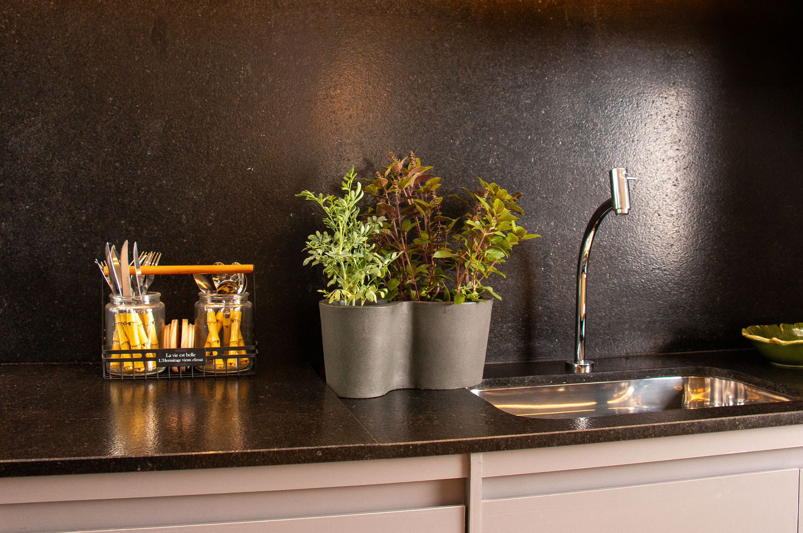 "Mulher sorridente cuidando das plantas em sua horta doméstica, demonstrando a alegria e satisfação de cultivar alimentos frescos em casa. Vasos e plantas bem cuidados em um ambiente interno, refletindo a praticidade e a beleza de uma horta caseira. A imagem ilustra a felicidade e os benefícios do cultivo doméstico."