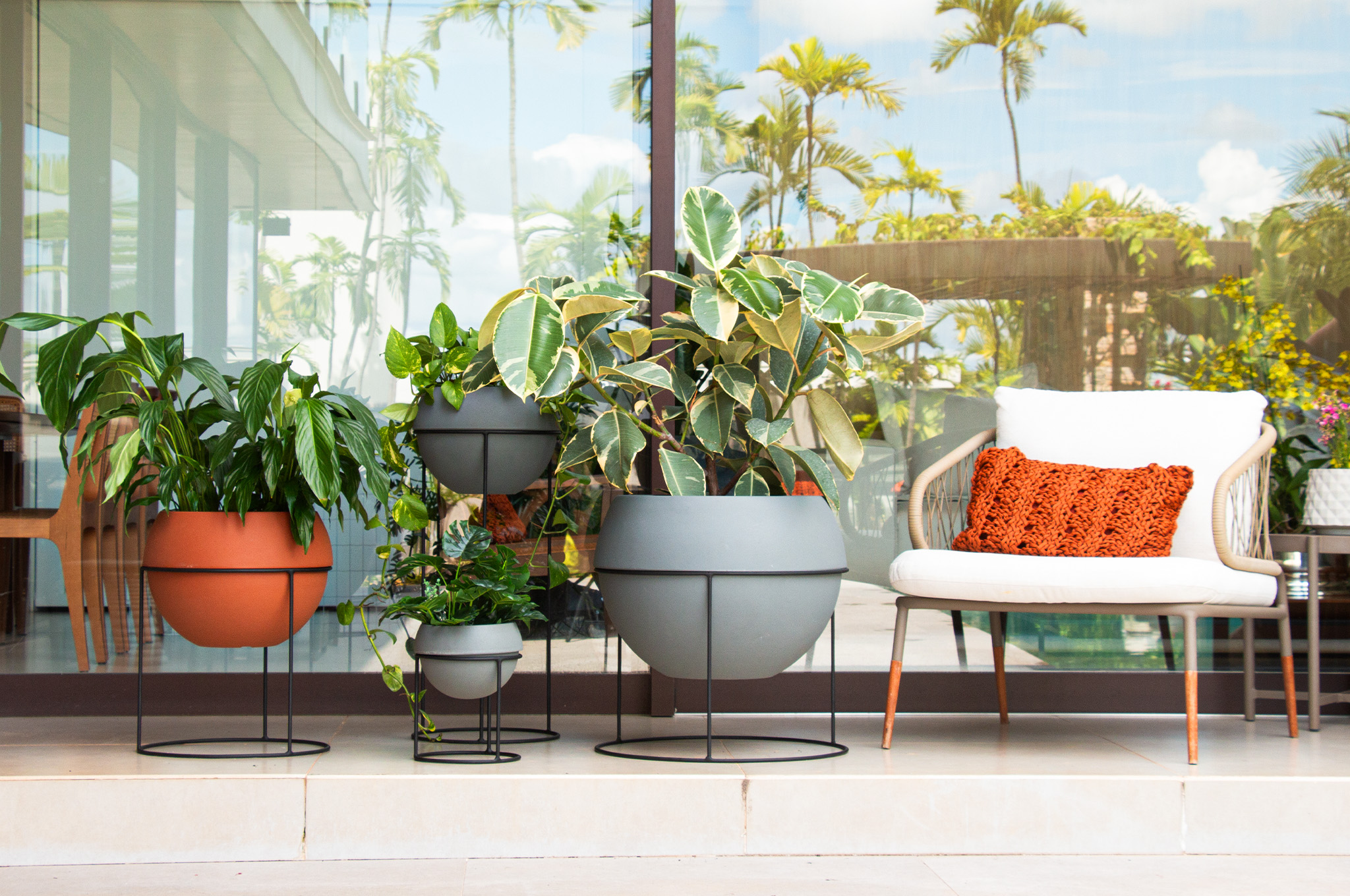 Varanda com vasos Vasap sustentáveis e plantas saudáveis em diferentes tamanhos.