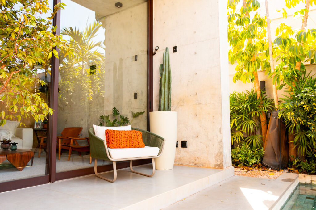 Vaso de plástico moderno com espada-de-são-jorge em varanda residencial iluminada.